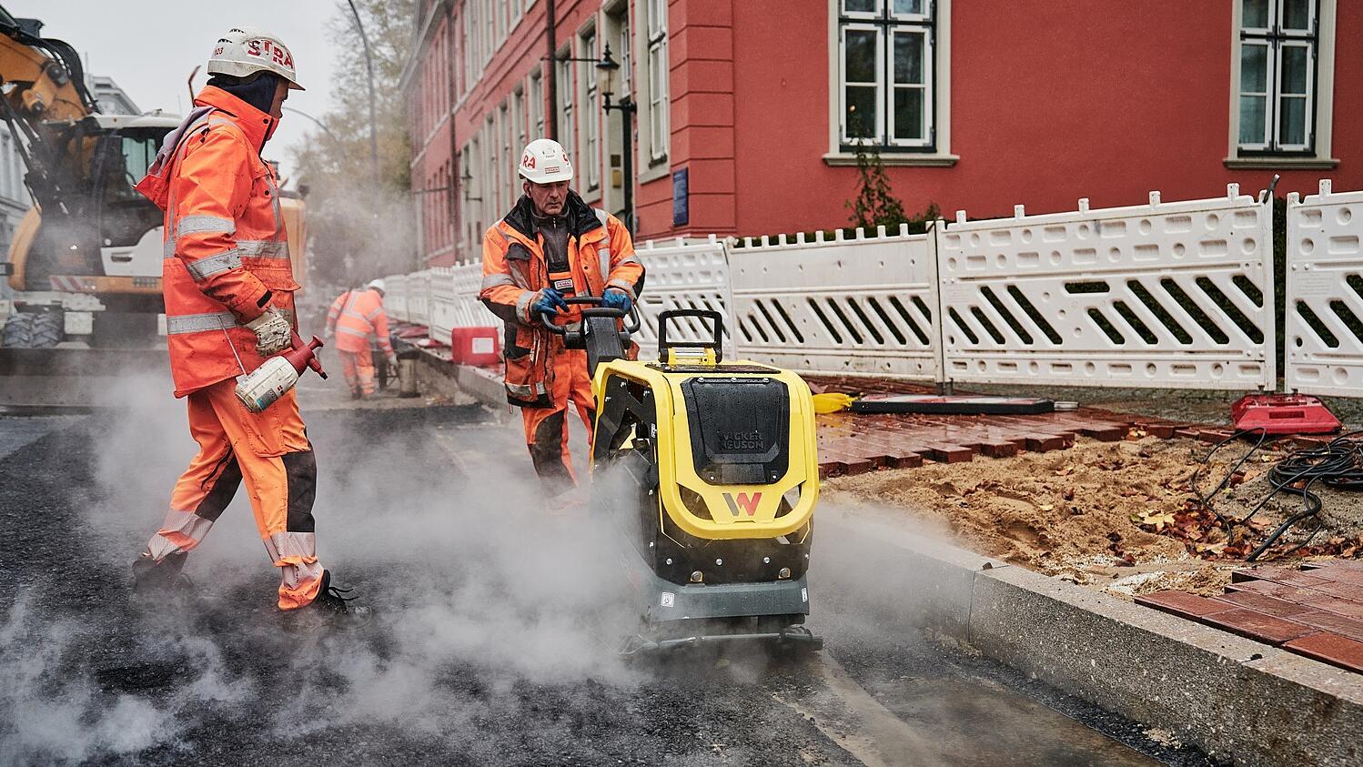 Stavební robotníci pokladajú cestu pomocou DPU62