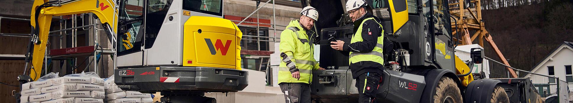 two customers standing in front of wacker neuson machines