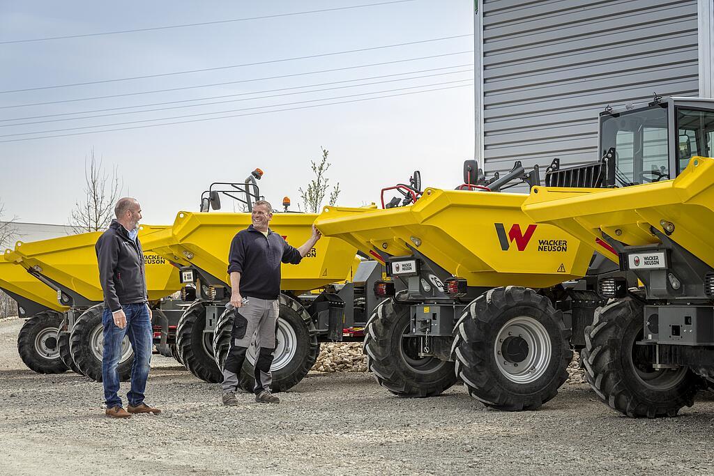 two customers in front of some wacker neuson dumper