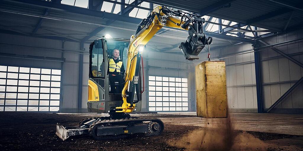 mini excavator in action in industry hall